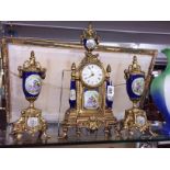 A 3 piece gilt and porcelain clock garniture.