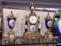 A 3 piece gilt and porcelain clock garniture.