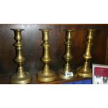 A set of 4 brass candlesticks.