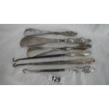 6 silver handled button hooks and shoe horns.
