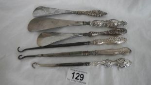 6 silver handled button hooks and shoe horns.