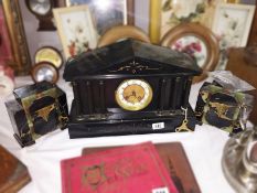 A 3 piece black clock garniture.