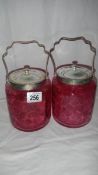 2 cranberry glass biscuit barrels.