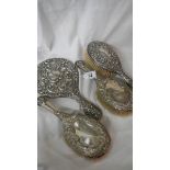 4 silver handled dressing table items including hand mirror.