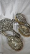 4 silver handled dressing table items including hand mirror.