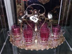 A tea stand with metal mounted glass tea cups and 6 small cranberry glass tumblers.