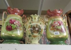 A pair of Staffordshire vases and a single vase.