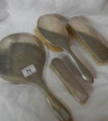 A 4 piece hall marked silver dressing table set comprising hand mirror and 3 hair brushes (mirror