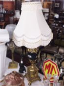 An urn shaped table lamp with shade.