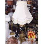 An urn shaped table lamp with shade.