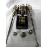 2 silver napkin rings, 2 silver handled button hooks, a silver thimble and 3 white metal thimbles.
