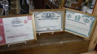 3 framed and glazed share certificates.