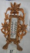 An early 20th century thermometer in a carved fruit wood frame, in good condition.