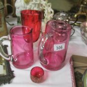 2 cranberry glass jugs and 3 other cranberry glass items.