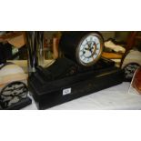 A black mantel clock and a pair of clock side pieces.