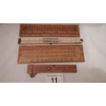 An antique ivory folding ruler, a bone ruler and 3 other wooden rulers.