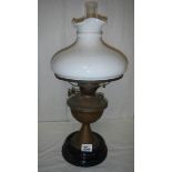 A brass oil lamp on pot base and complete with mushroom shade.