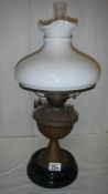 A brass oil lamp on pot base and complete with mushroom shade.