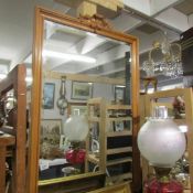 A large bevel edged mirror in wood frame.