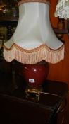 An urn shaped table lamp with shade.