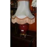 An urn shaped table lamp with shade.