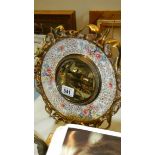 A brass and ceramic circular mirror.