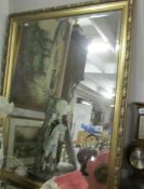 A large gilt framed bevel edged mirror.