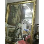 A large gilt framed bevel edged mirror.