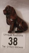 A carved rosewood netsuke as a dachsund, with small ivory disc inset, 2" tall, in good condition.