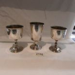 A pair of silver goblets and a single goblet all with engraved coats of arms, B E S & Co.