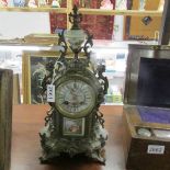 A French mantle clock with enamel dial and porcelain panel.