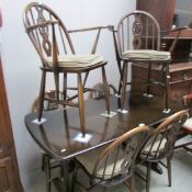 An Ercol style dining table and 6 chairs.