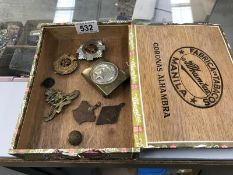 An old cigar box containing badges, medals, buckles & button etc.