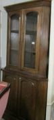 A freestanding mahogany corner cupboard with glazed top.
