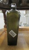 A cast green glass bottle inscribed 'V. Hoytema & Co.