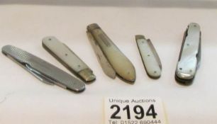 4 silver and mother of pearl pen knives and one other.