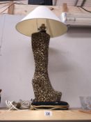 A table lamp in the shape of a ladies knee high boot with leopard print