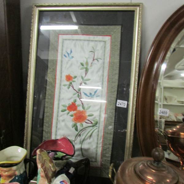 A framed and glazed early embroidered panel.