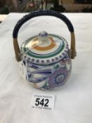 A Poole pottery honey pot with wicker handle