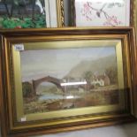 A framed and glazed watercolour depicting a bridge over a river, glass a/f.