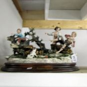 A porcelain figure group depicting boys at play.
