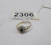 A gold ring (hall mark indistinct) set sapphire and white stone.