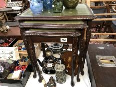 A nest of 3 small tables each having embossed green leather inlays under glass