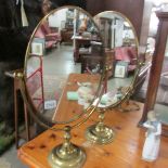 A pair of oval brass mirrors.