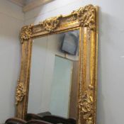 A large gilt framed bevel edged mirror - approximately 86.25" x 52.5" / 223 x 133.25 cm overall.