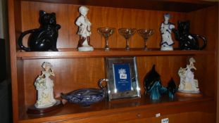 2 shelves of ornaments including 2 Poole pottery dolphins, 2 black cat teapots, a Murano swan bowl,