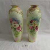 A pair of hand painted Doulton Burslem vases featuring floral studies and signed C Hart.