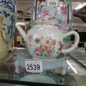 A Chinese oriental teapot on stand.