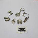 A pair of silver cuff links, a silver ingot on chain, a silver locket,