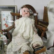 A Victorian porcelain headed doll with composition body (fingers a/f).